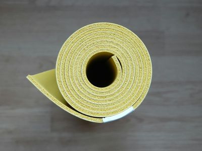 Rolled yoga mat and a wooden block.